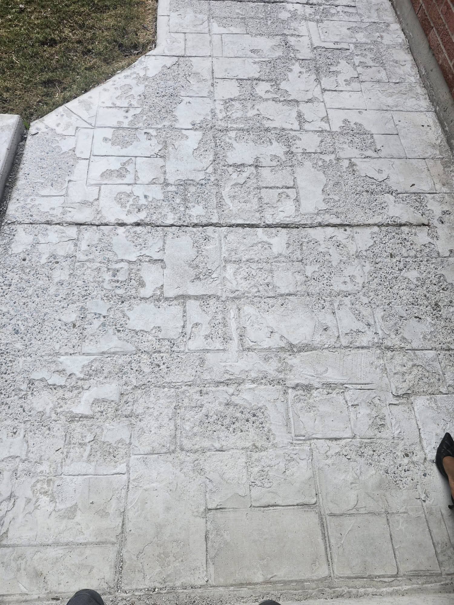 Worn stamped concrete driveway before resurfacing